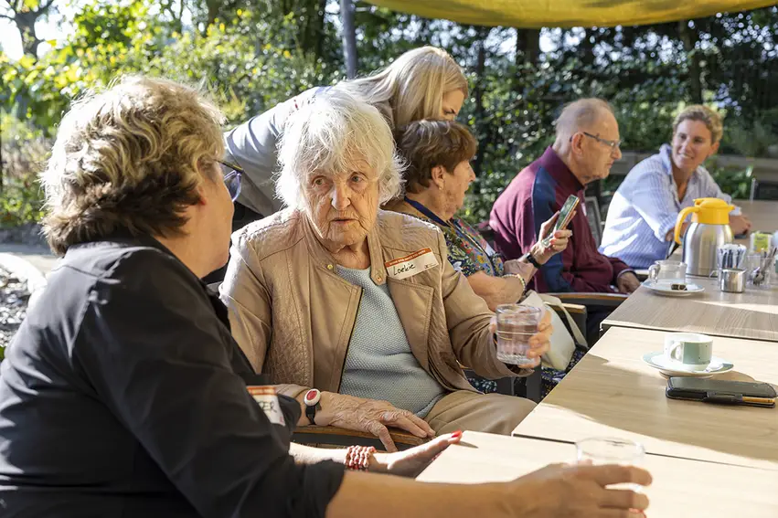 Mensen drinken koffie terwijl ze samen buiten zitten