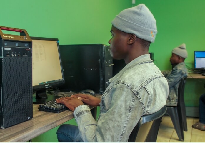 Jonge man leert computerskills en is werkzaam voor IT-projecten van Rhiza in Zuid-Afrika