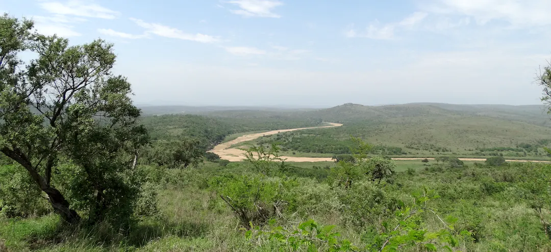 Afbeelding van het Hluhluwe iMfolozi-park in Zuid-Afrika met ongerepte wildernis die de Kenchaan Foundation probeert te beschermen.