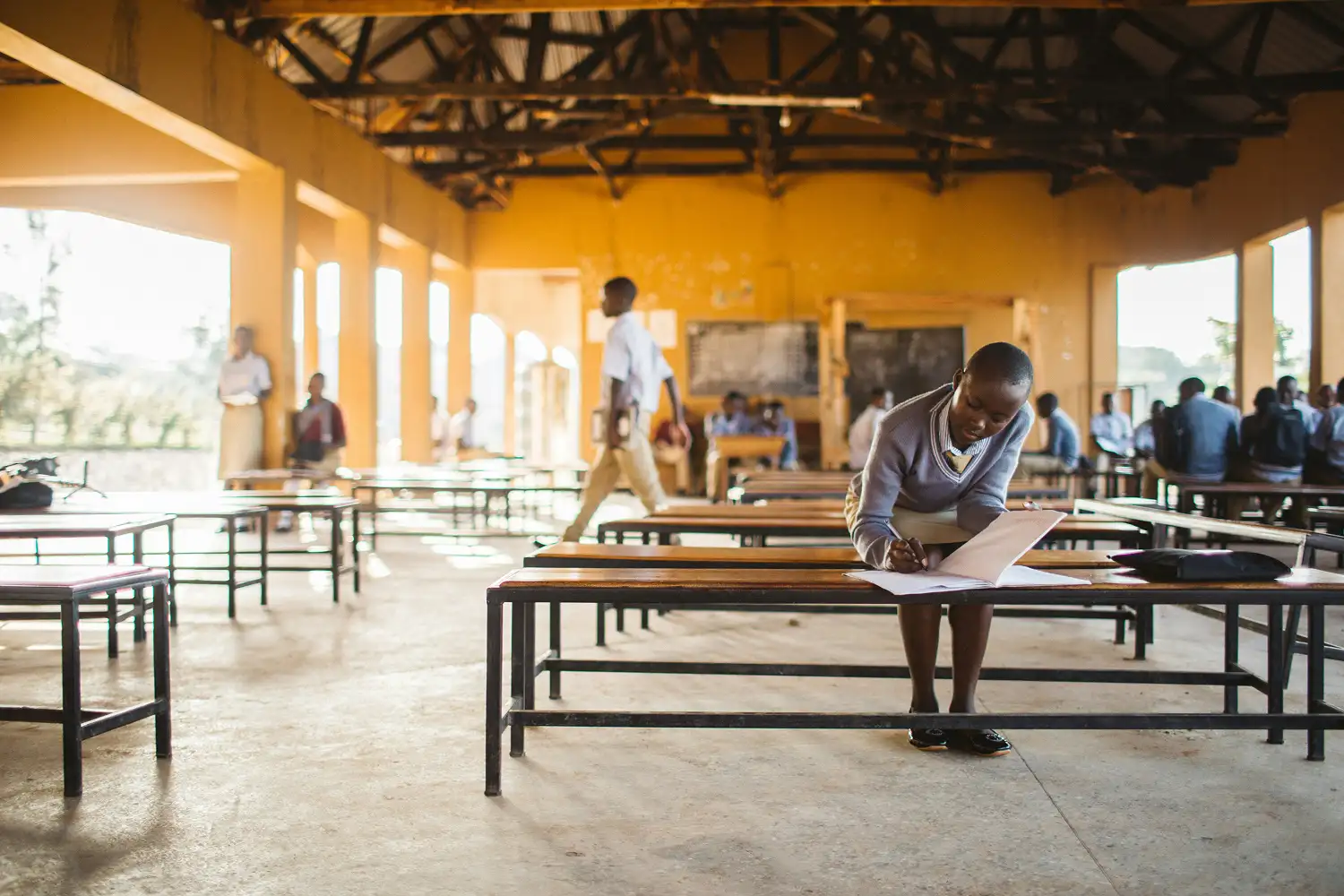 Een meisje slaat haar schoolboek open in een schoolruimte
