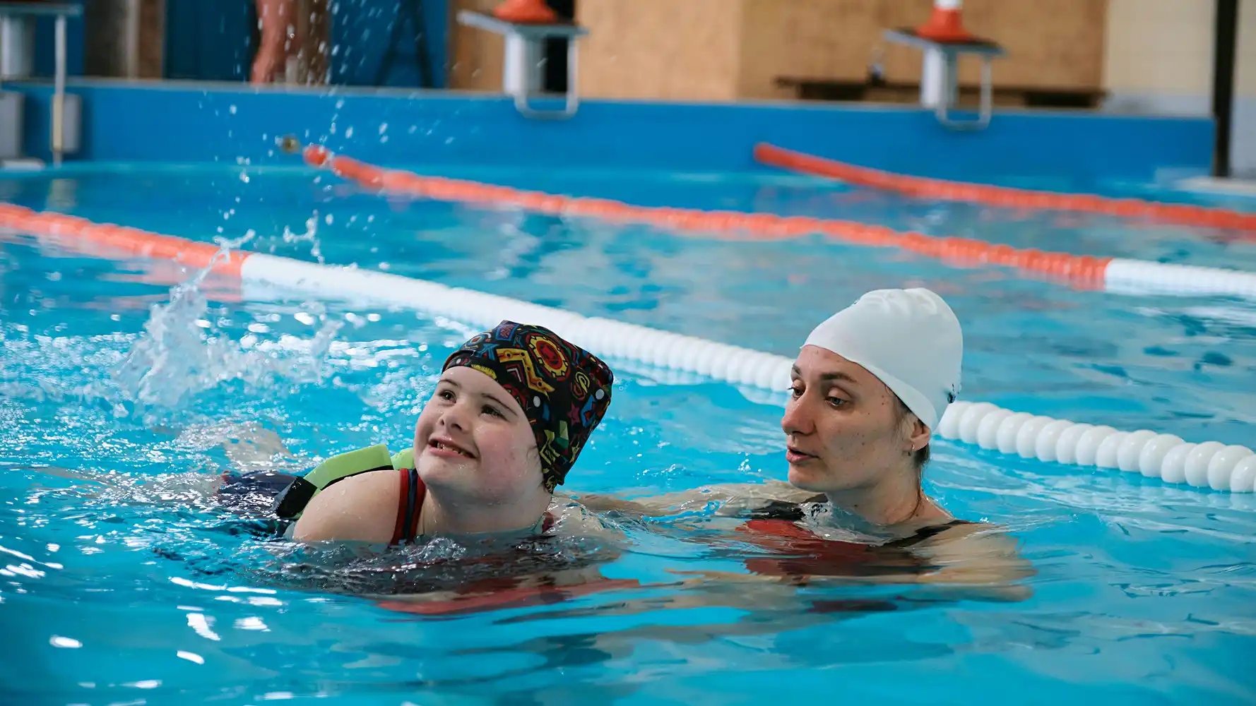 Een kind krijgt zwemles met ondersteuning van een instructeur