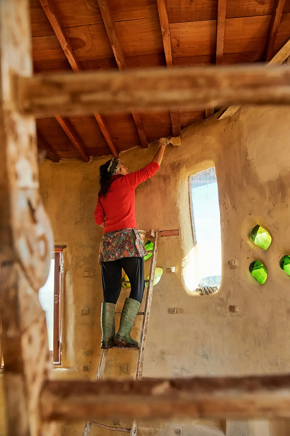Persoon op een ladder die de binnenmuur van een huis schildert