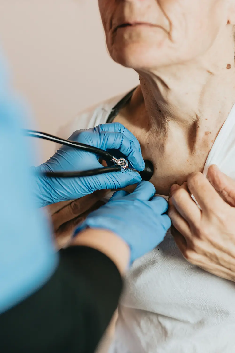 Zorgverlener luistert met een stethoscoop naar de borst van een oudere persoon